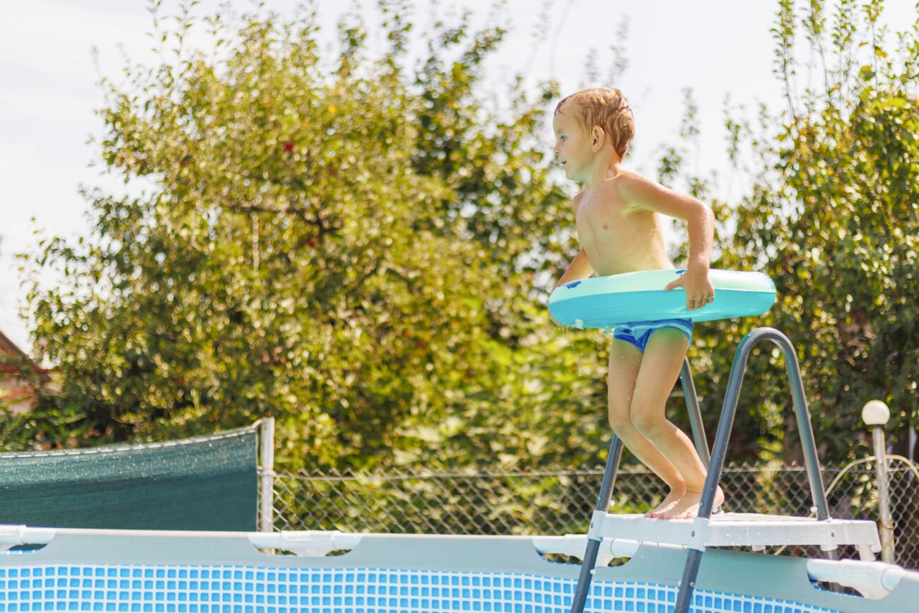 child jumping in above-ground pool